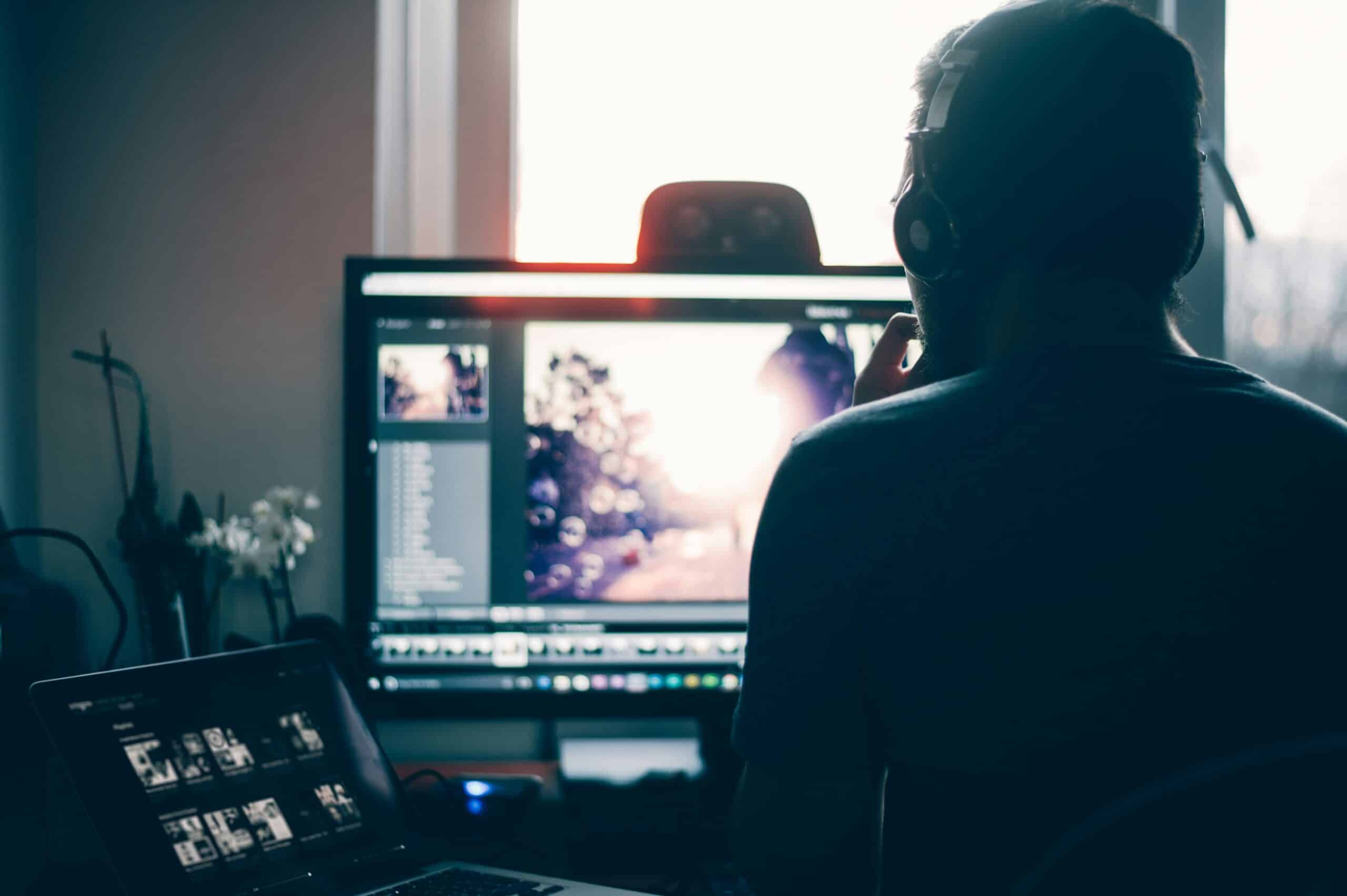 backlit person at computer editing a photo with lightroom scaled