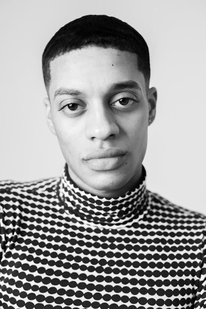 Fotografía en blanco y negro de un hombre que lleva una moderna camisa de cuello alto con estampado de puntos. Foto de Edölia Stroud.