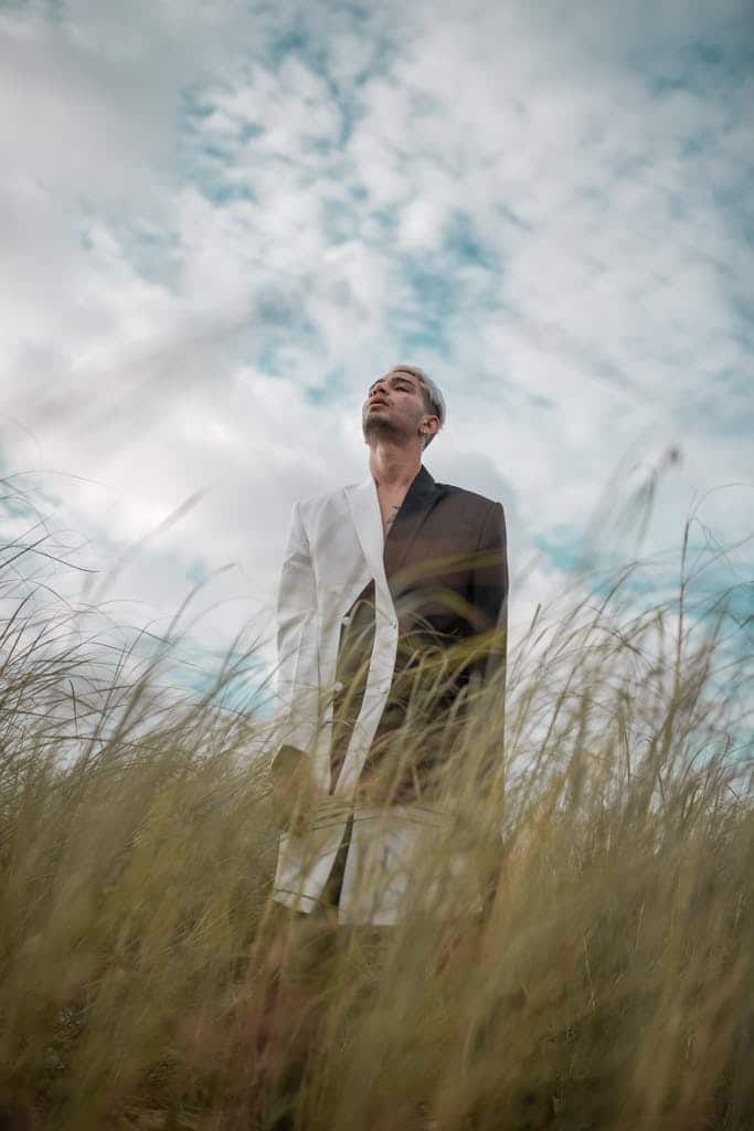 man wearing a black and white suit in a grassy field