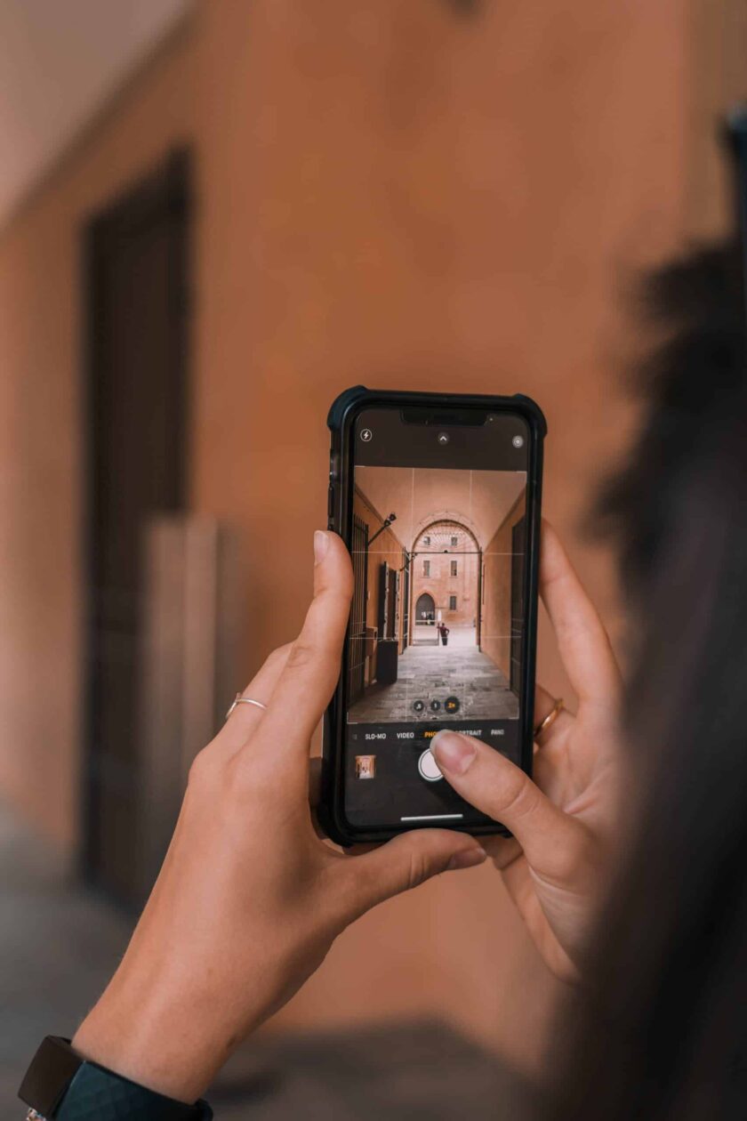 person holding black iphone while taking street photograph scaled e1687541133290