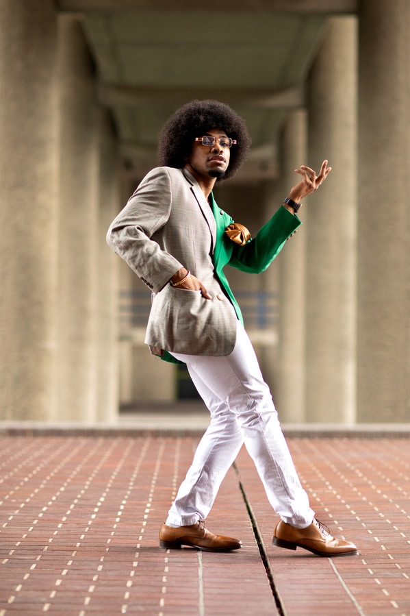 Fotografía de Remi McQuen de un hombre posando con pantalones blancos y americana bicolor