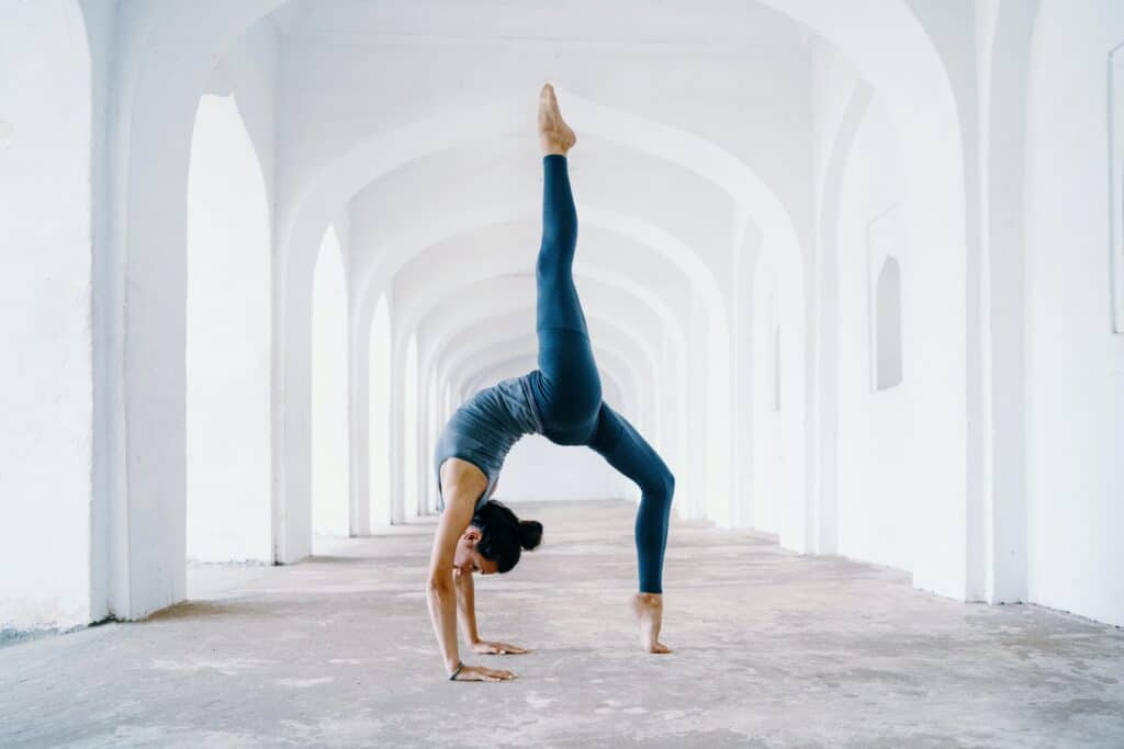 Femme faisant la pose de la flexion arrière sous les arcs blancs