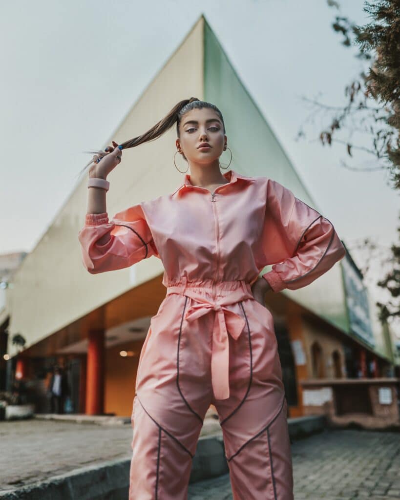 Frau trägt rosa Jumpsuit mit schwarzen Details